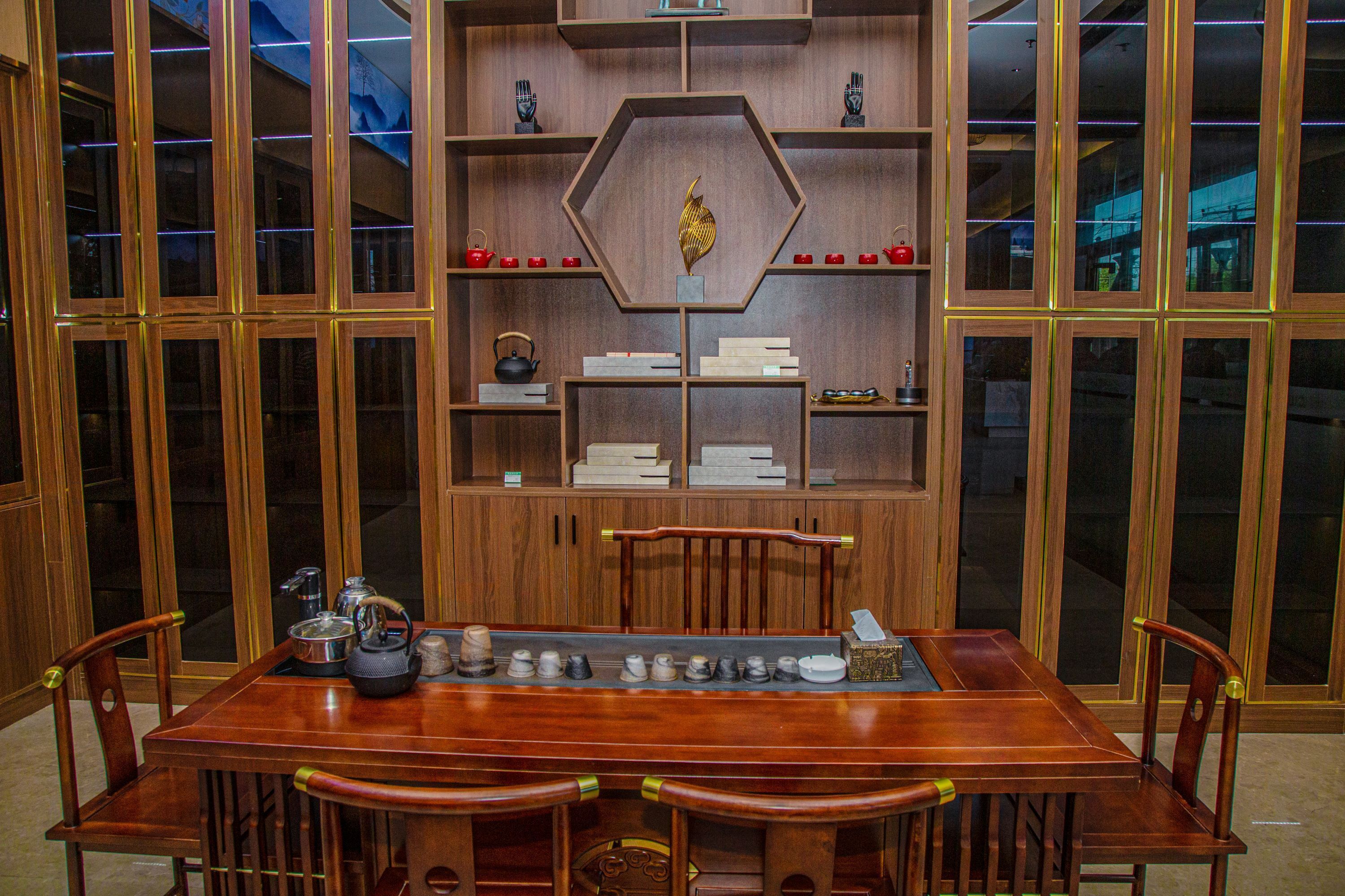 Una mesa de comedor de madera con sillas, rodeada de armarios de madera con estantes.