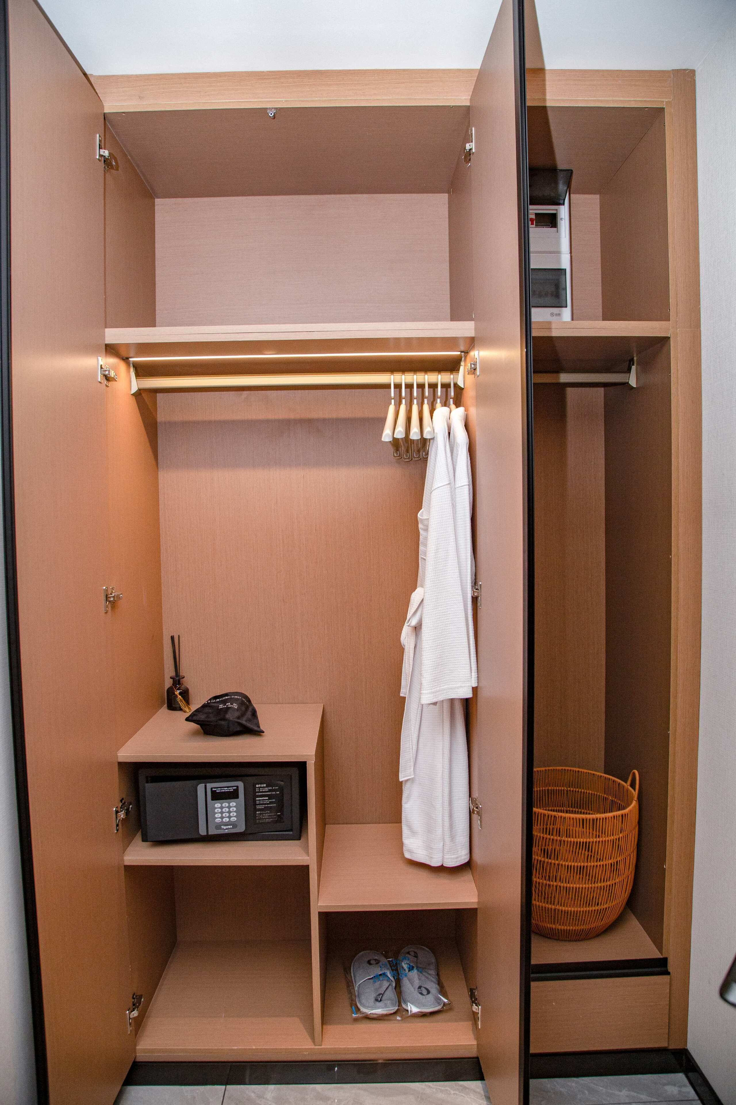 Un vestidor con estantes, una barra para colgar ropa, un zapatero y una cesta.