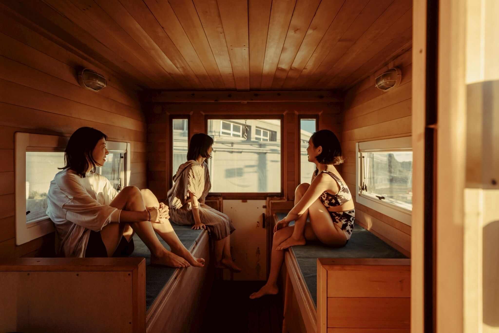 Una cabaña con paredes de madera y un interior iluminado por ventanas.