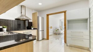A modern kitchen with a central island, stainless steel appliances, and a view into a living area. - Lizarran by Interhome (Figueres)