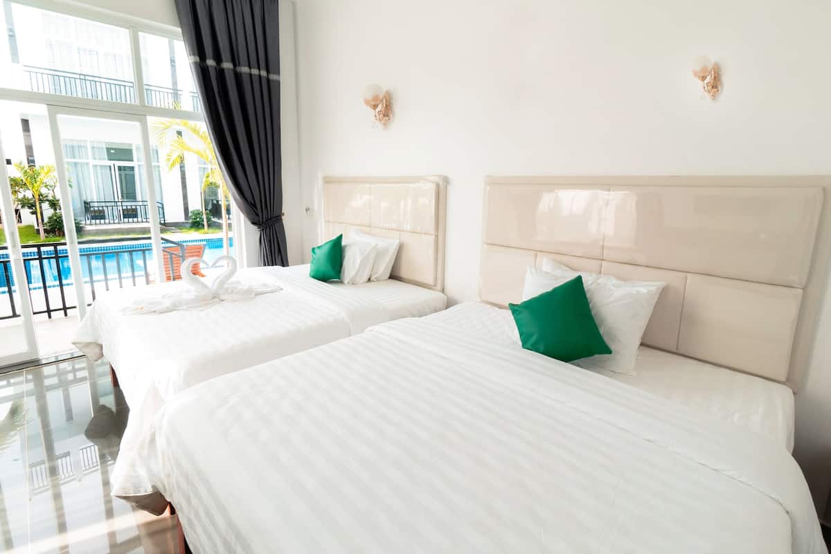 A hotel room with two beds, a glass floor, and a view of a swimming pool.