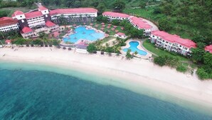 Un complexe hôtelier comprenant plusieurs b âtiments, une grande piscine et une plage.