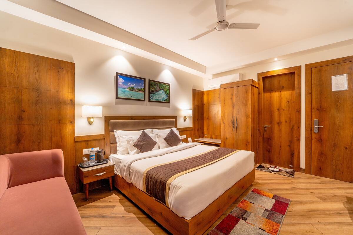 A hotel room with a wooden bed, nightstands, a ceiling fan, and wooden wardrobes.
