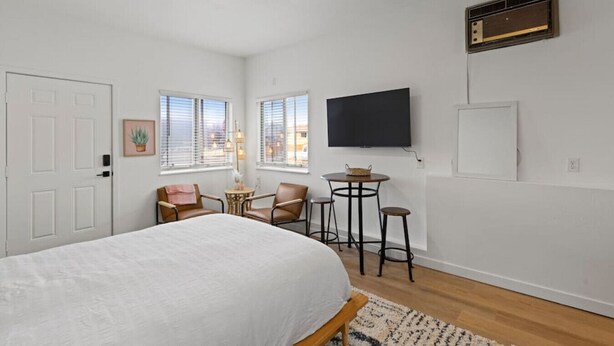 Une chambre à coucher avec un lit, une télévision, un bureau et une chaise.
