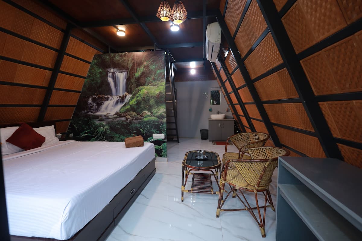 Quarto com cama, uma mesa pequena e cadeiras.