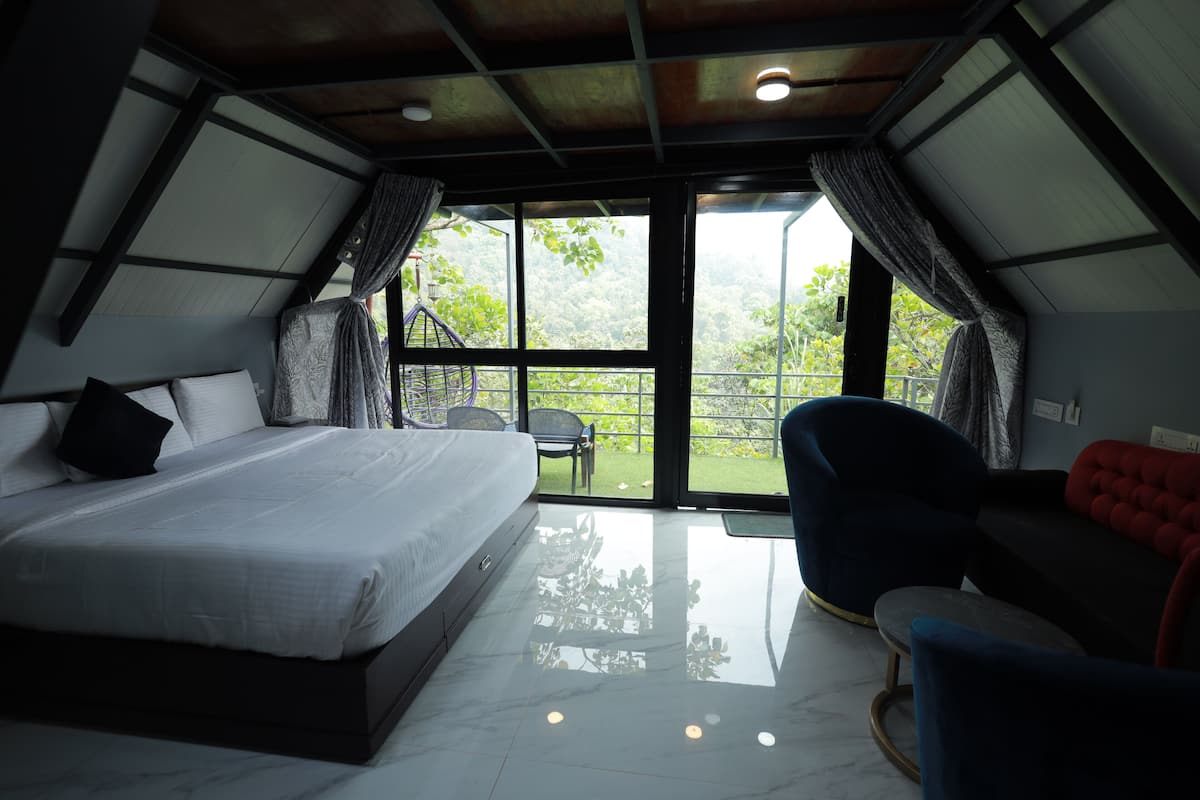 Quarto com cama, poltrona e sofá.