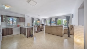 A modern kitchen with a dining area, a sofa, and a lamp. - 3 bedroom with private garden walking distance to everything (Marbella)