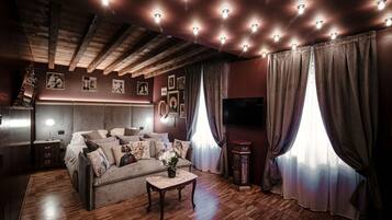 Una sala de estar acogedora con un sofá, una mesa de centro y un televisor.