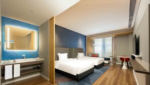 A modern hotel room with two beds, a large mirror, a vanity with a sink, and a television. - Holiday Inn Express Haiyan by IHG (Jiaxing)