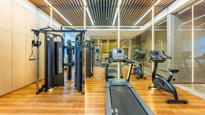 A modern gym with exercise equipment, a wooden floor, and a glass wall. - Holiday Inn Express Haiyan by IHG (Jiaxing)
