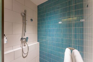 A bathroom with a shower, tiled walls, and a towel rack. - Holiday Inn Express Haiyan by IHG (Jiaxing)