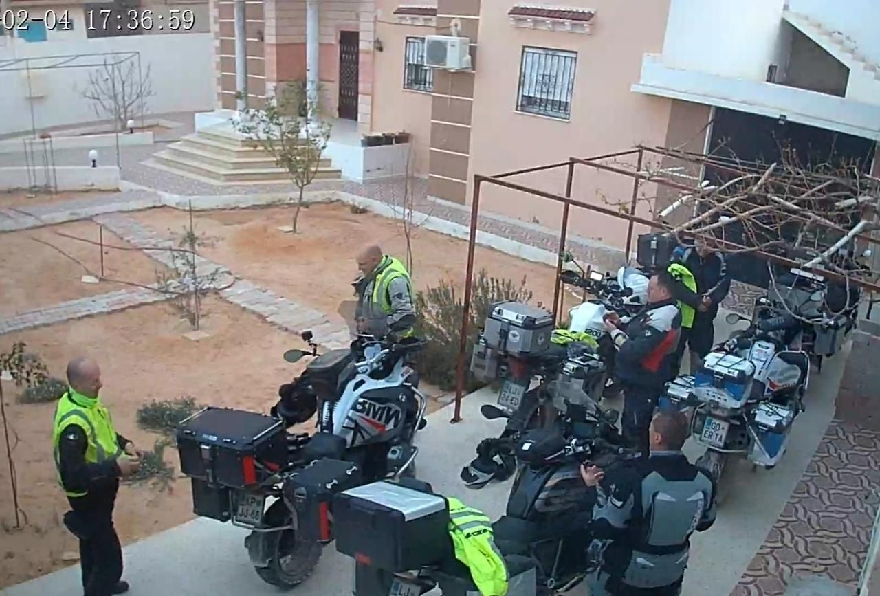 A group of motorcycles parked outdoors, possibly in a parking lot or courtyard.