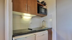 A compact kitchen with a dishwasher, a microwave, and a sink. - Spacious duplex for 5 at the foot of the slopes (Plagne Soleil)