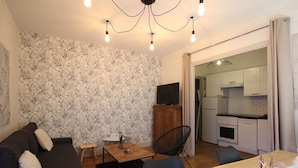 A compact living space with a sofa, a dining table, and a kitchen area.
