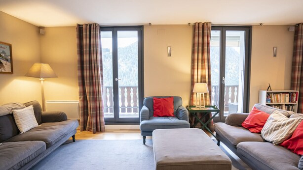A cozy living room with two sofas, a coffee table, and a bookshelf. - Spacious chalet for 8, close to center and lifts (Châtel)
