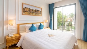 A hotel room with a large bed, a painting on the wall, and a balcony with blue curtains. - Lime Villa - King
Viziati in questa incantevole camera (Hội An)