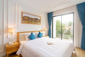 Une chambre d’hôtel avec un grand lit, un tableau au mur et un balcon avec des rideaux bleus.