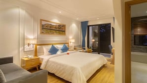 A hotel room with a large bed, bedside tables, a chair, a painting, and a view of the outside. - Lime Villa - King
Viziati in questa incantevole camera (Hội An)