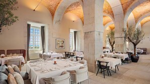 Un comedor amplio con techos altos en arco y varias mesas dispuestas para comer.