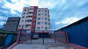 A multi-story building with a sign reading "Tavoo Court" and a gated entrance. - Repose Stay - 2br, Wifi, Cctv, Parking in Karen (Nairobi)