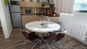Una cucina moderna con un tavolo da pranzo rotondo, due sedie e un forno a incasso.