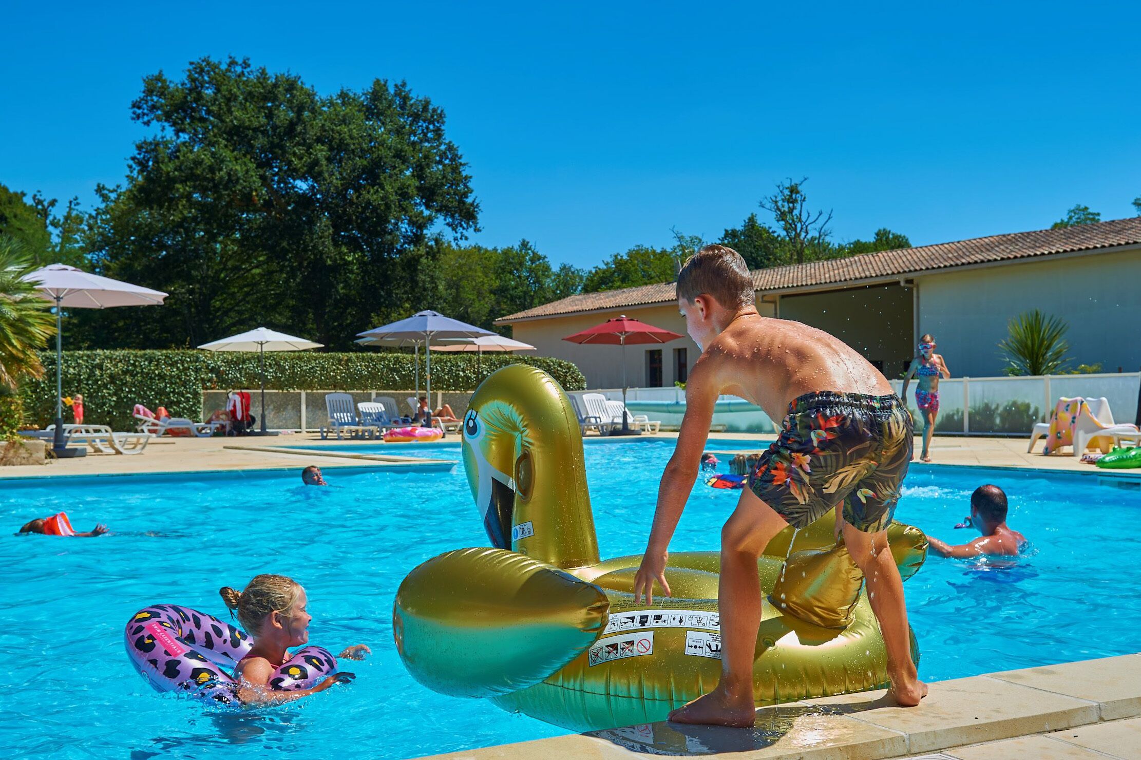 Una piscina al aire libre de temporada, sombrillas, tumbonas
