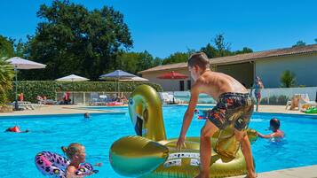 Una piscina al aire libre de temporada, sombrillas, tumbonas