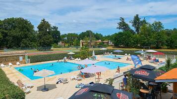 Una piscina al aire libre de temporada, sombrillas, tumbonas