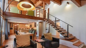 A spacious living area with a modern staircase, wooden flooring, and a dining area with a table and chairs. - Modern Retreat Near Dog-Friendly Beach & Eateries (Carnelian Bay)