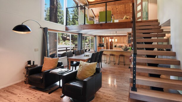 A modern interior with a wooden staircase, a dining area, and a kitchen. - Modern Retreat Near Dog-Friendly Beach & Eateries (Carnelian Bay)