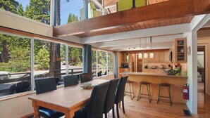 A modern kitchen with wooden cabinets, a central island, and bar stools. - Modern Retreat Near Dog-Friendly Beach & Eateries (Carnelian Bay)