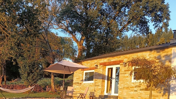 A stone building with a stone pathway leading to a hammock and outdoor seating area. - La Casita a haven of peace to escape and relax, close to cities and beaches. (Lugo Galicia)