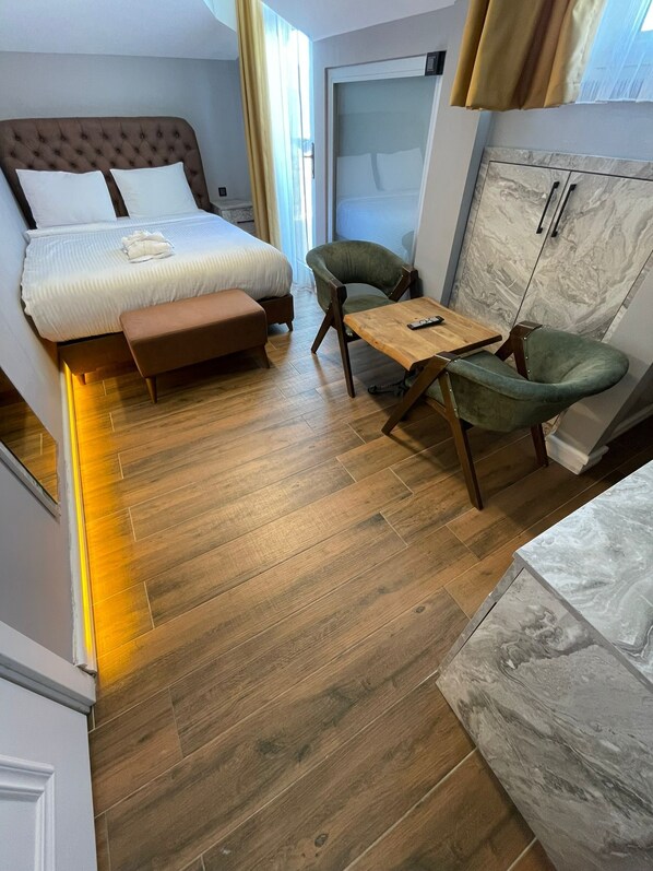 A hotel room with a bed, a bench, a table, and a chair. - Greenwich Istanbul Hotel (Istanbul)