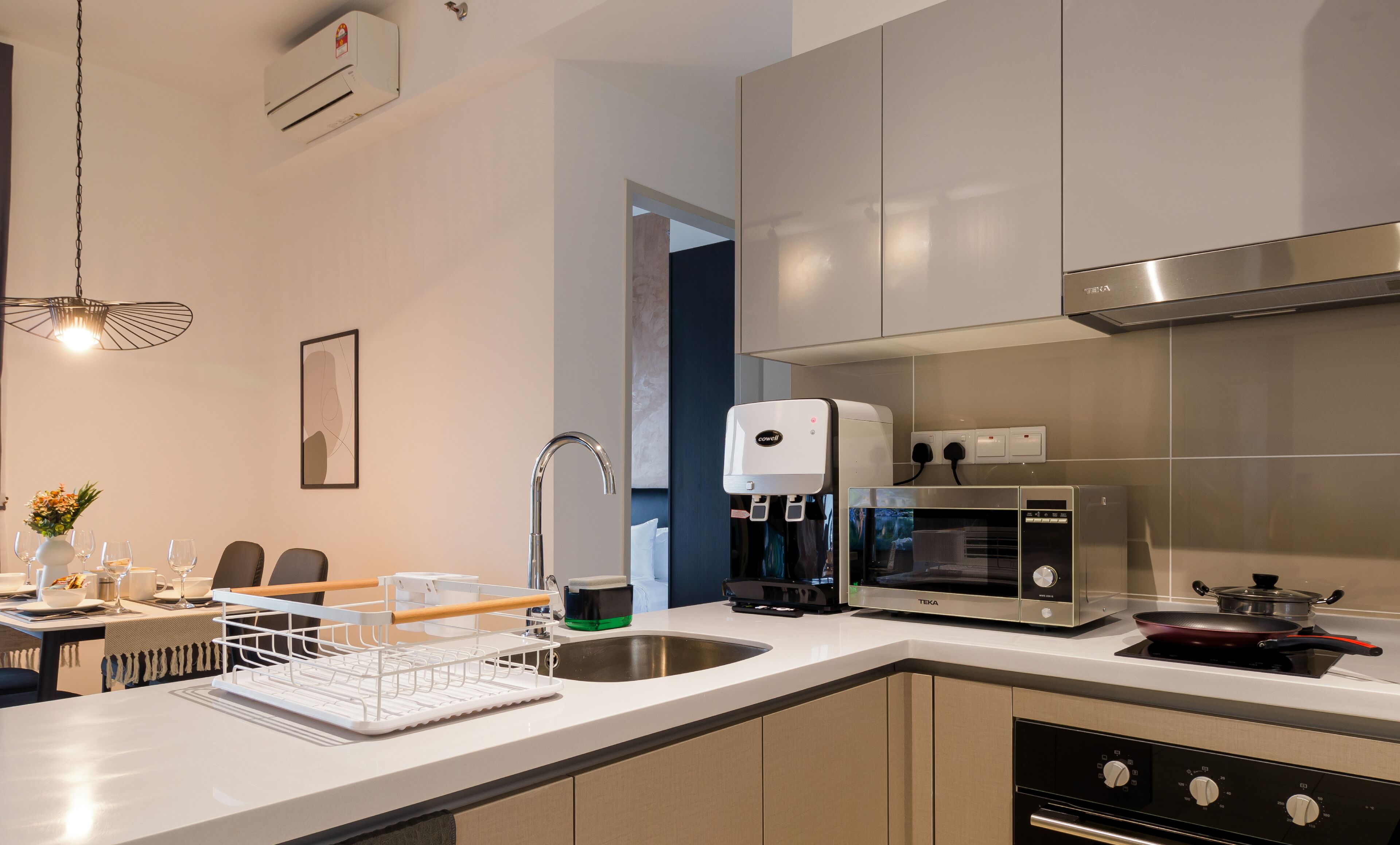 Une cuisine moderne équipée d’un lave-vaisselle intégré, d’une machine à café, d’un four à micro-ondes et d’une cuisinière.