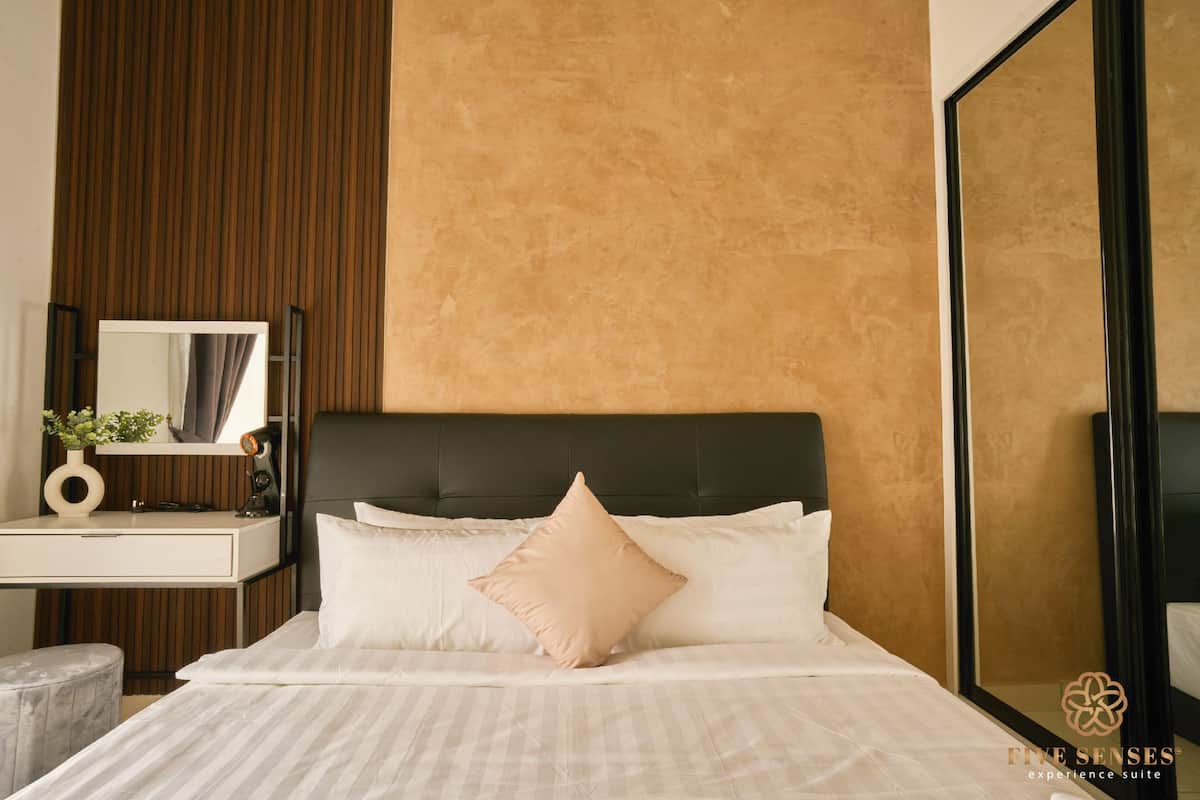 Ein modernes Hotelzimmer mit einem großen Bett, einem Nachttisch, einem Spiegel und einem großen Wandspiegel.