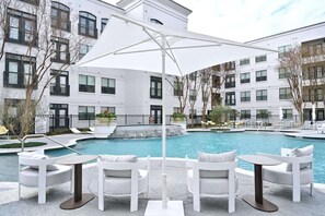 Relax by the pool surrounded by a low wall and modern architecture.