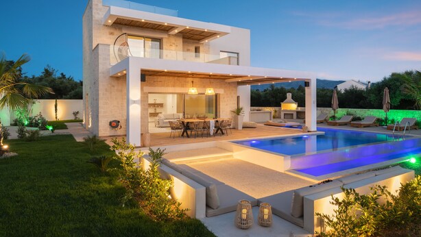 A modern two-story house with a swimming pool, outdoor seating, and a well-lit patio area. - Sohora Estate up to 14 persons (Chania)