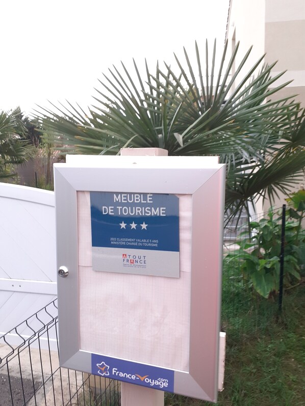 Schild an einem Gebäude mit der Aufschrift 'MEUBLE DE TOURISME' und einem Wappen '2022 Bewertung gültig für 5 Jahre' des französischen Tourismusministeriums.