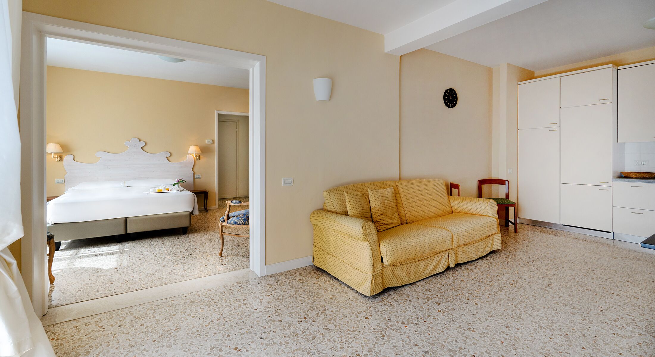 Ein Hotelzimmer mit Bett, einer Couch, einem Kleiderschrank und einem Spiegel.