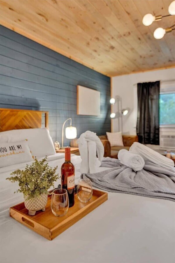Experience a warm and inviting atmosphere in this cozy hotel room, complete with a comfortable seating area and a thoughtfully prepared space for relaxation.