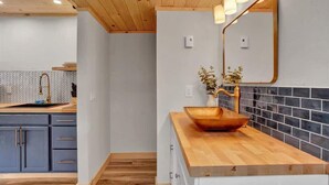 Eine moderne Küche mit Holzausbau, einer Rückwand aus Fischgrätmuster-Fliesen und einer Holz Arbeitsplatte.