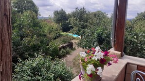 A garden view with a stone wall, a path, and a flower pot on a balcony. - Gîte Dans Maison en Pierre, Avec Piscine, à la Campagne, Proche Villefranche (Savignac)