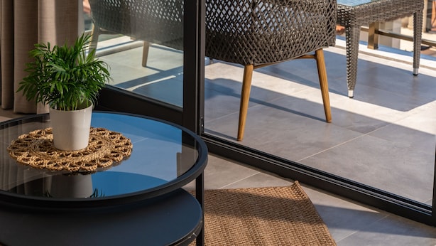 A balcony with a glass table, wicker chairs, and a potted plant. - KAYA APARTMENTS KALAMAR (Kas)