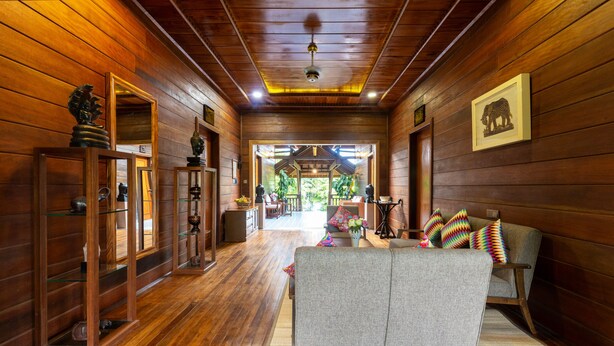 A wooden interior with a sofa, shelves, and a framed picture on the wall. - Atoh's Maison (Siem Reap)
