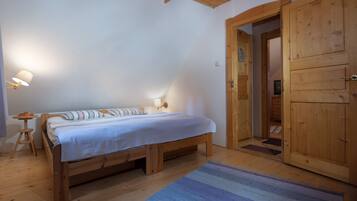 Un dormitorio con una cama de madera, una mesita de noche, una lámpara y un armario.