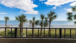 Een strand met palmbomen en een heldere lucht.