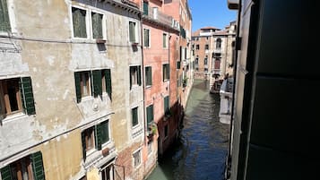 A narrow canal flanked by historic buildings with balconies and windows.