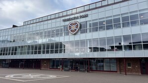 En moderne bygning med glasfacade, et tydeligt logo og et reception område.