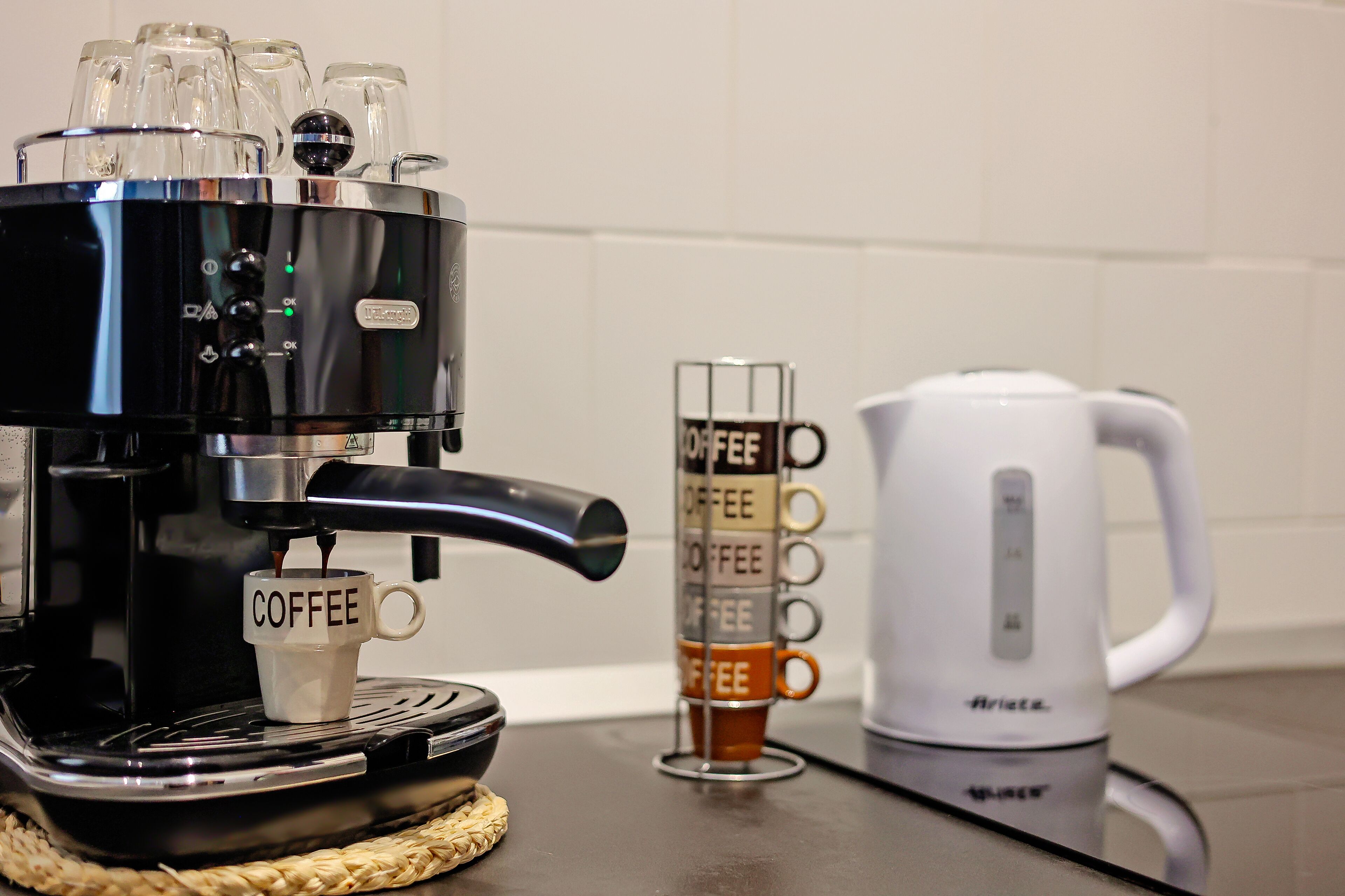 A coffee machine with a coffee cup labeled "COFFEE" and a coffee maker on a countertop.