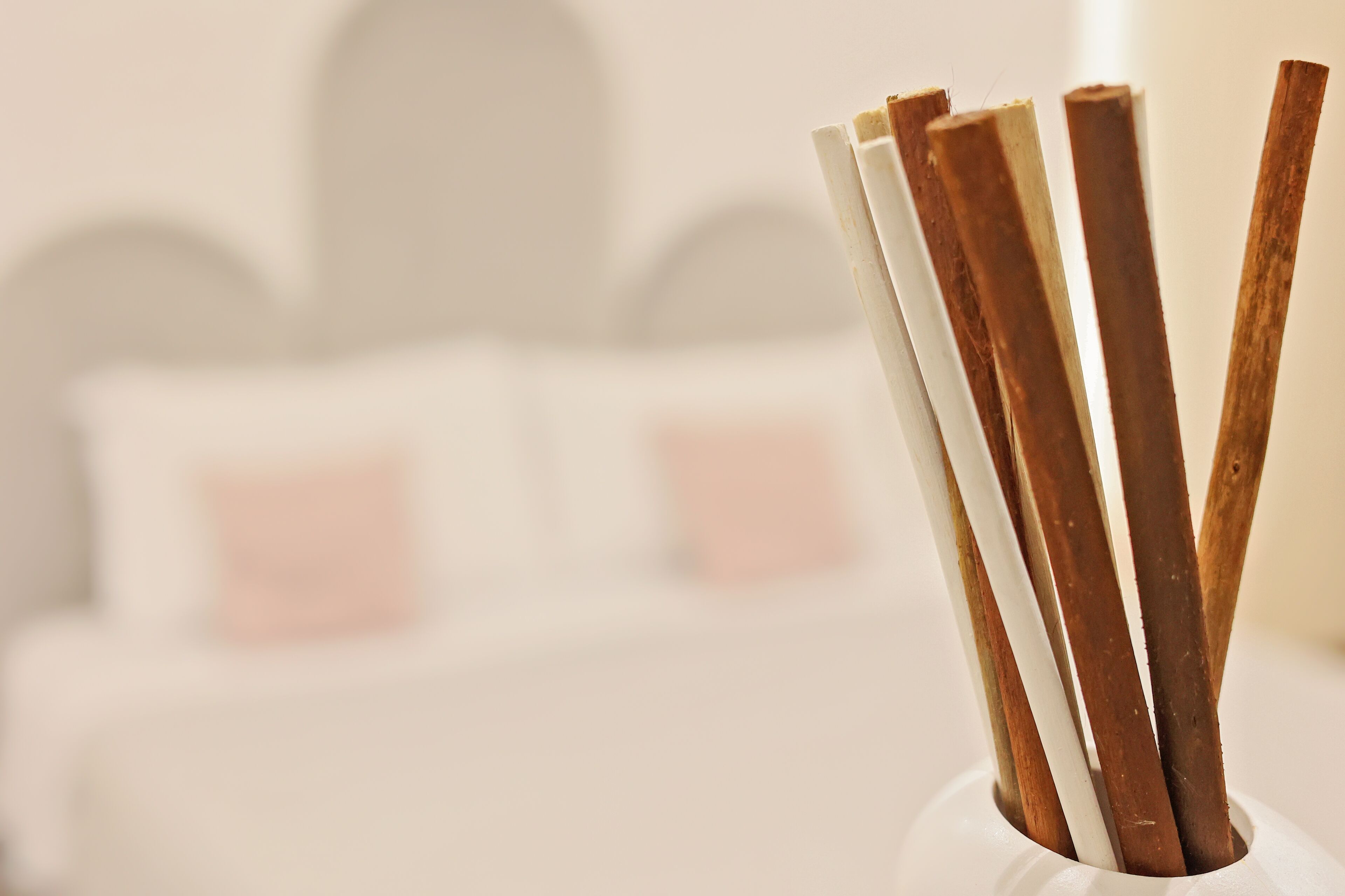 A white candle holder with several candles in various colors.